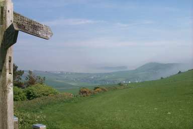 Picture of a view along a sign over a hilly landscape, some fog in the distance
