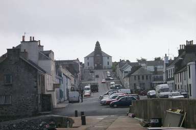 Picture of a street going up a hill from a pier, a round church at the top