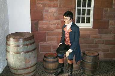Picture of a puppet depicting Robert Burns sitting on a cask