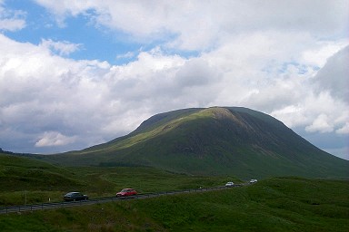 Picture of a road through a glen, some blue sky above