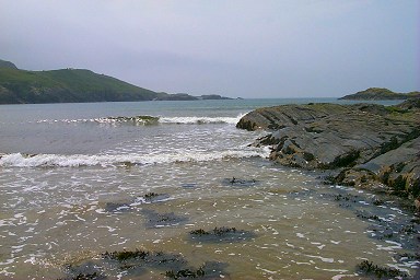 Picture of waves breaking on a beach and rocks