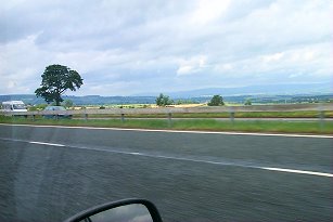 Picture of a view out of a car over the motorway, sun breaking through