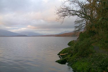 Picture of the coastline at Loch Lomond, mild sunshine despite clouds above