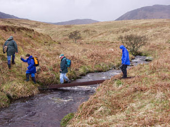 Picture of people crossing a burn