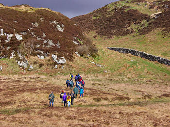 Picture of walkers approaching the hill with the carved faces