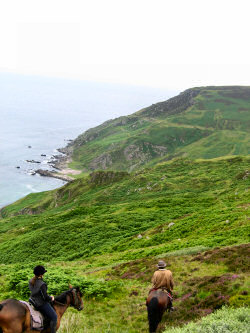 Picture of riders on the cliffs high above the water