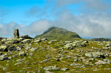 Picture of a summit trig point with another summit in the distance
