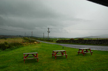 Picture of dark clouds over a green hilly landscape