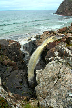 Picture of a waterfall with the sea in the background
