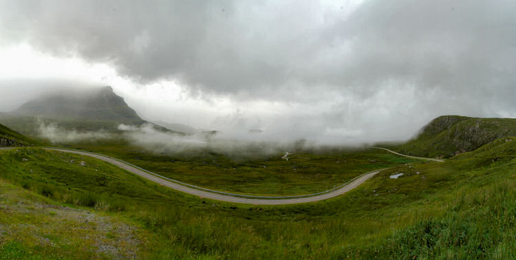 Picture of a road in the highlands with low clouds lingering over it
