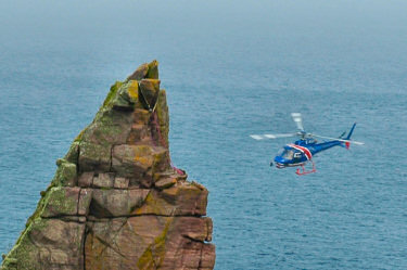 Picture of a helicopter near a rock stack