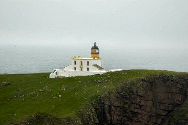 Picture of a lighthouse on cliffs, mist in the background