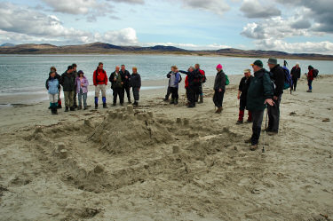 Picture of a group of walkers around a large sandcastle