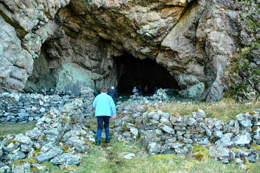 Picture of people in front of a huge cave