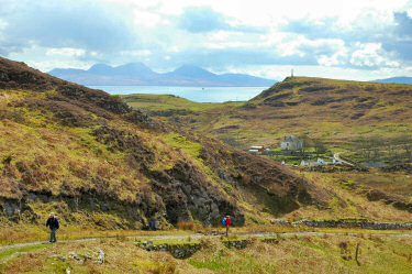 Picture of a view from a hill through two hills out to the sea