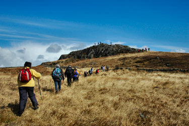 Picture of walkers approaching a rocky knoll