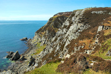 Picture of some people on quite high cliffs, the people are only tiny dots