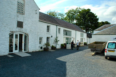 Picture of small businesses in an old building, two people walking past