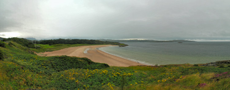 Picture of a beach in a bay under a cloudy sky