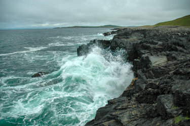 Picture of a wave breaking over low cliffs