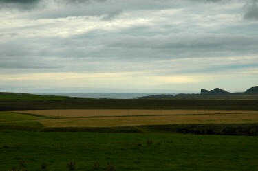 Picture of a view over fields to a bay in the distance