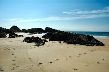 Picture of rock formations on a sandy beach in brilliant sunlight