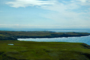 Picture of a view south over an island with the sea bathed in sunshine