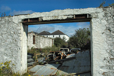 Picture of rusty car wrecks in a disused distillery building