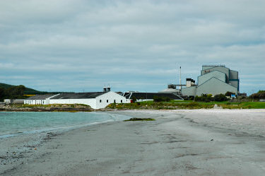 Picture of a beach with a distillery and maltings in the background
