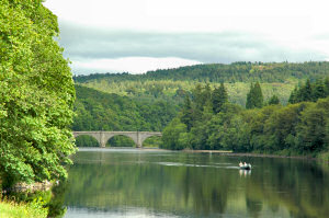 Picture of a view over a river, an old bridge in the distance