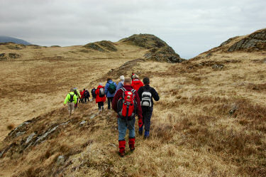 Picture of a group of walkers approaching an ancient hill fort