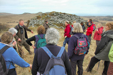 Picture of a group of walkers standing in front of the remains of a dun