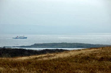 Picture of a ferry on an overcast day with the sun breaking through in places