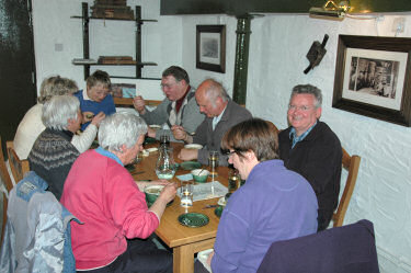 Picture of a group of people sitting at a table eating lunch