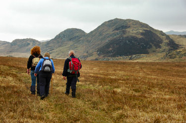 Picture of 3 walkers in front of some hills