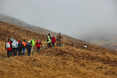 Picture of walkers in the hills under dark clouds and rain