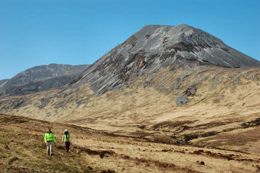 Picture of two walkers with scree covered mountains in the background