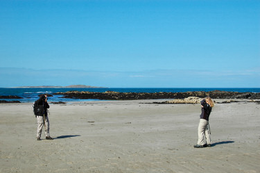 Picture of two people on a beach taking a picture of each other