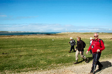 Picture of walkers on a track, a sea loch in the background