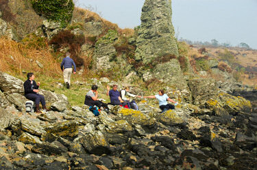 Picture of a few walkers sitting down for lunch on some rocks