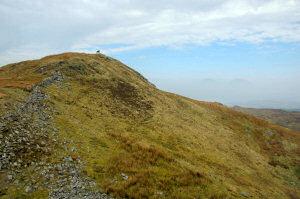 Picture of a hilltop, two other hills just visible in the haze in the distance