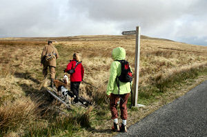 Picture of three walkers turning off at a sign post to Evans Walk