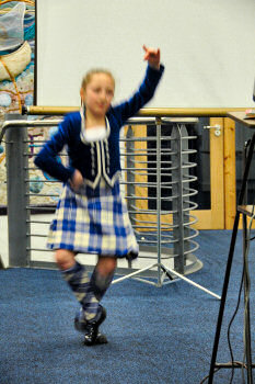 Picture of a dancer of traditional Scottish dance in full flight