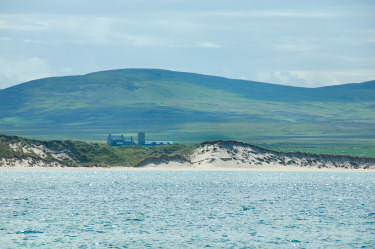 Picture of dunes and a farm seen over the sea