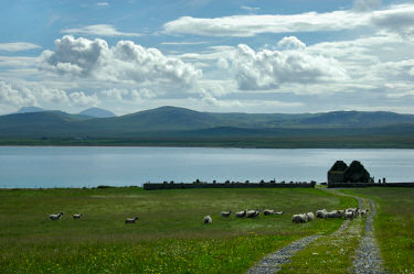Picture of the ruins of Kilnave Chapel with Loch Gruinart behind, the Paps of Jura in the distance