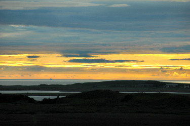 Picture of a beautiful sunset with a ship out on sea in the distance