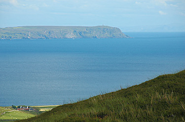 Picture of a view over a sea loch to the end of some cliffs with a monument on the top