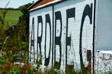 Picture of the word 'Ardbeg' painted on the side of a distillery warehouse