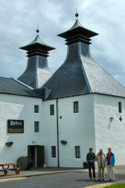 Picture of a couple with their daughter in front of a distillery