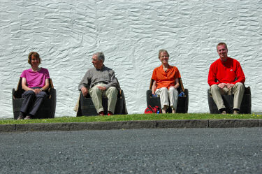 Picture of a family sitting in chairs made from casks, closer view than previous picture